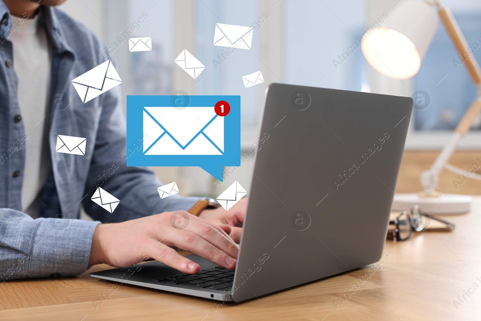 Image of Man using laptop at table, closeup. Envelopes as symbol of message over computer