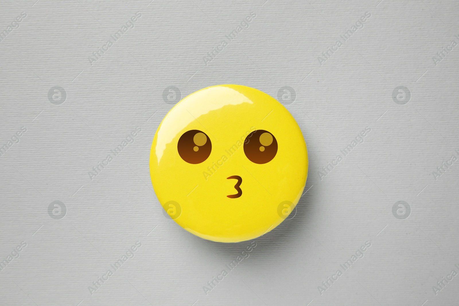 Image of Badge with kissing face on grey background