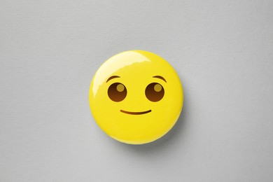 Badge with smiling face on grey background