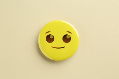 Image of Badge with smiling face on beige background