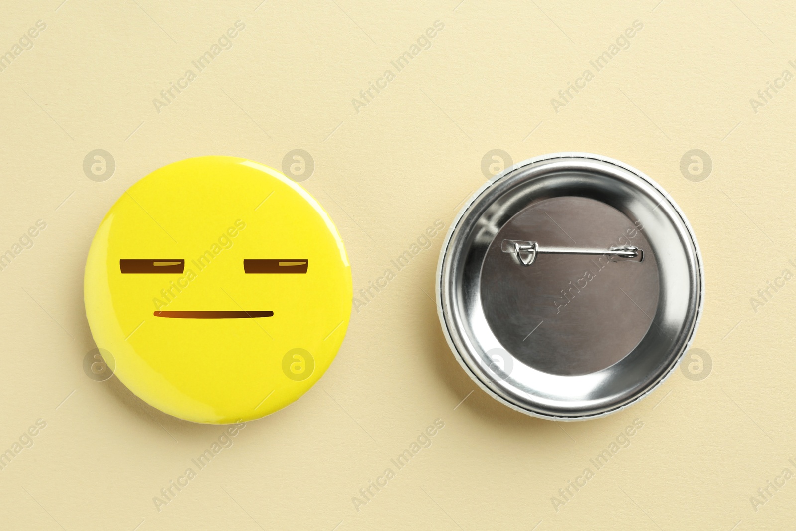 Image of Badges on beige background. One with distrustful or sleepy face