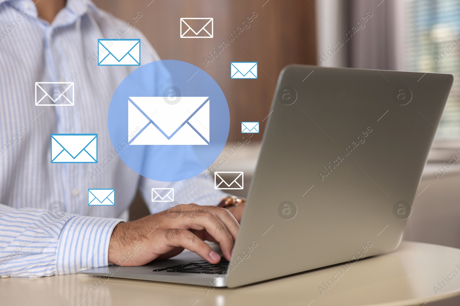 Image of Man using laptop at table, closeup. Envelopes as symbol of message over computer