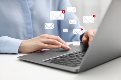 Woman using laptop at table, closeup. Envelopes as symbol of message over computer