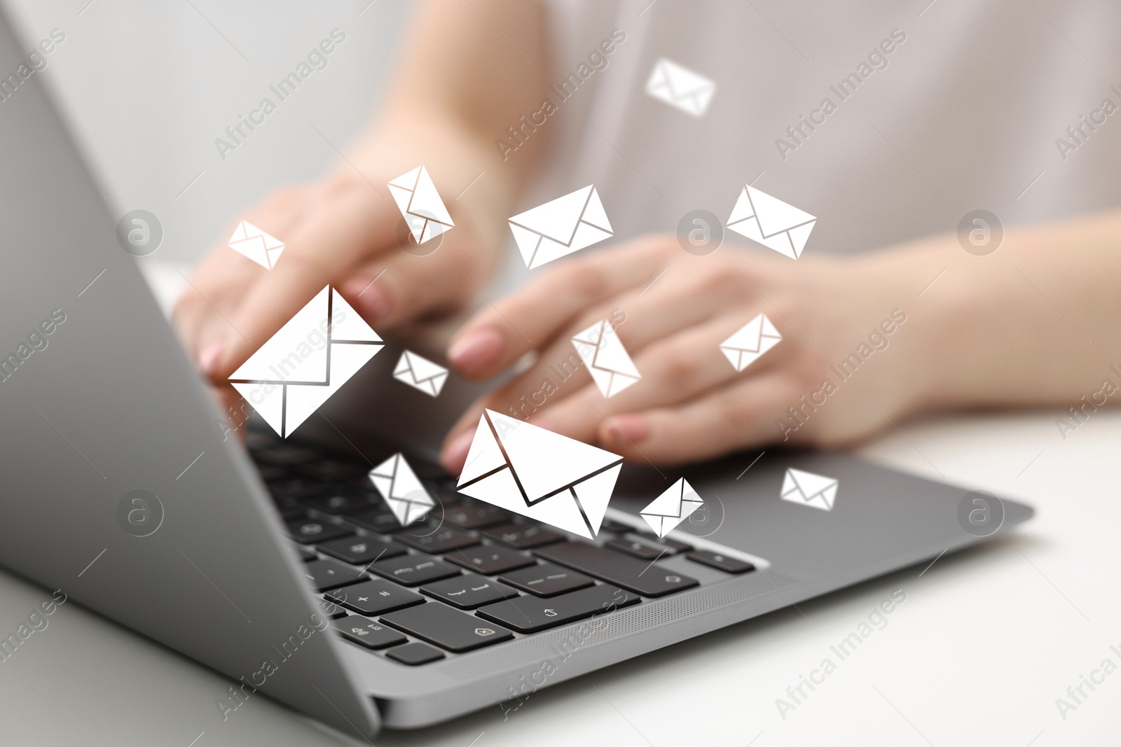 Image of Woman using laptop at table, closeup. Envelopes as symbol of message over computer