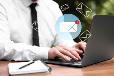 Image of Man using laptop at table, closeup. Envelopes as symbol of message over computer