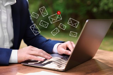 Image of Man using laptop at table, closeup. Envelopes as symbol of message over computer