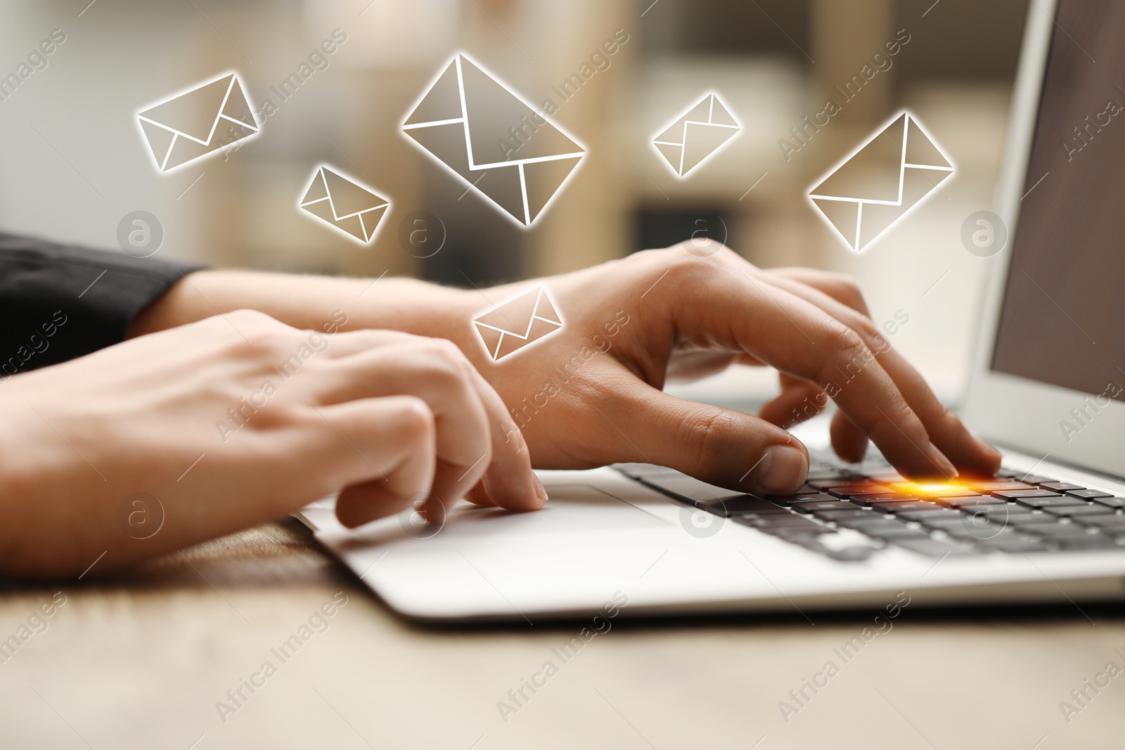 Image of Man using laptop at table, closeup. Envelopes as symbol of message over computer