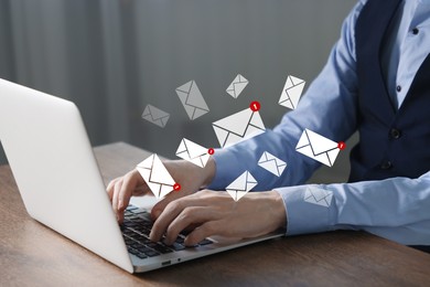 Image of Man using laptop at table, closeup. Envelopes as symbol of message over computer