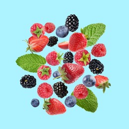 Image of Mix of fresh berries in air on light blue background