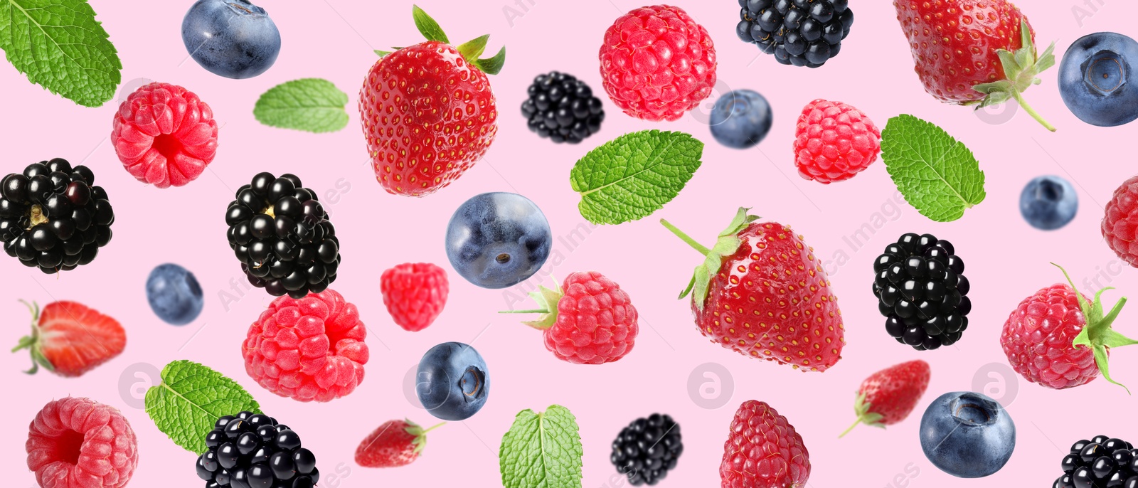 Image of Mix of fresh berries in air on pink background