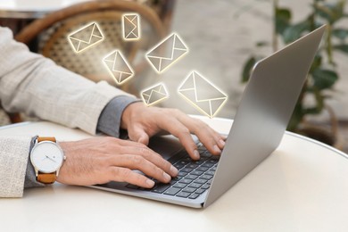 Man using laptop at table, closeup. Envelopes as symbol of message over computer