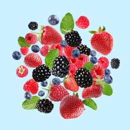 Image of Mix of fresh berries in air on light blue background