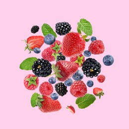 Image of Mix of fresh berries in air on pink background