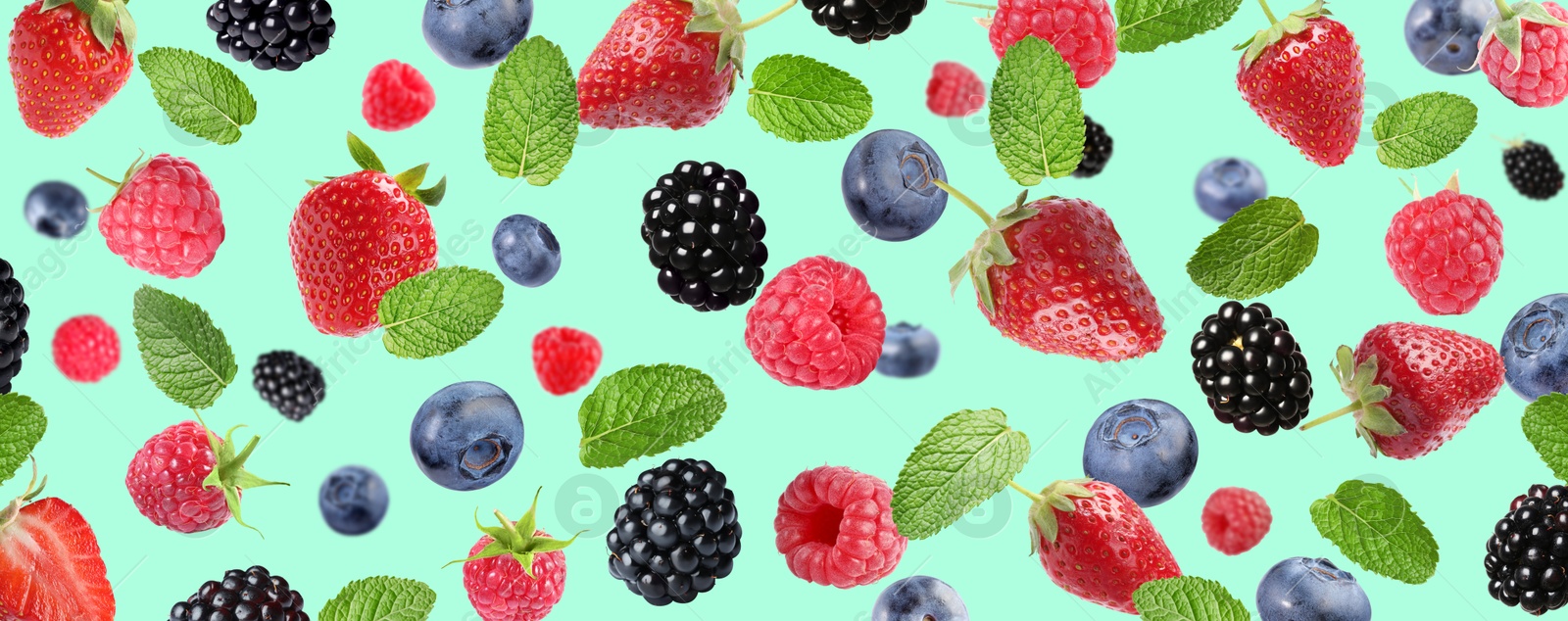 Image of Mix of fresh berries in air on turquoise background