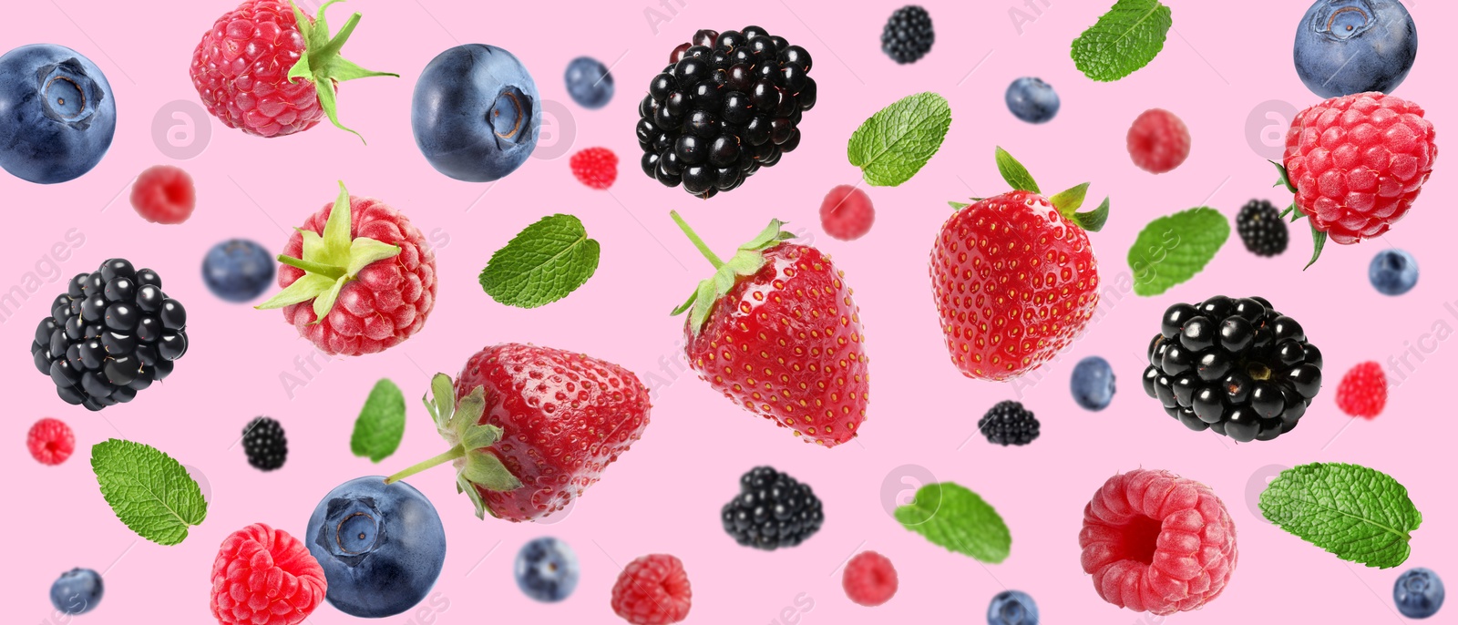 Image of Mix of fresh berries in air on pink background