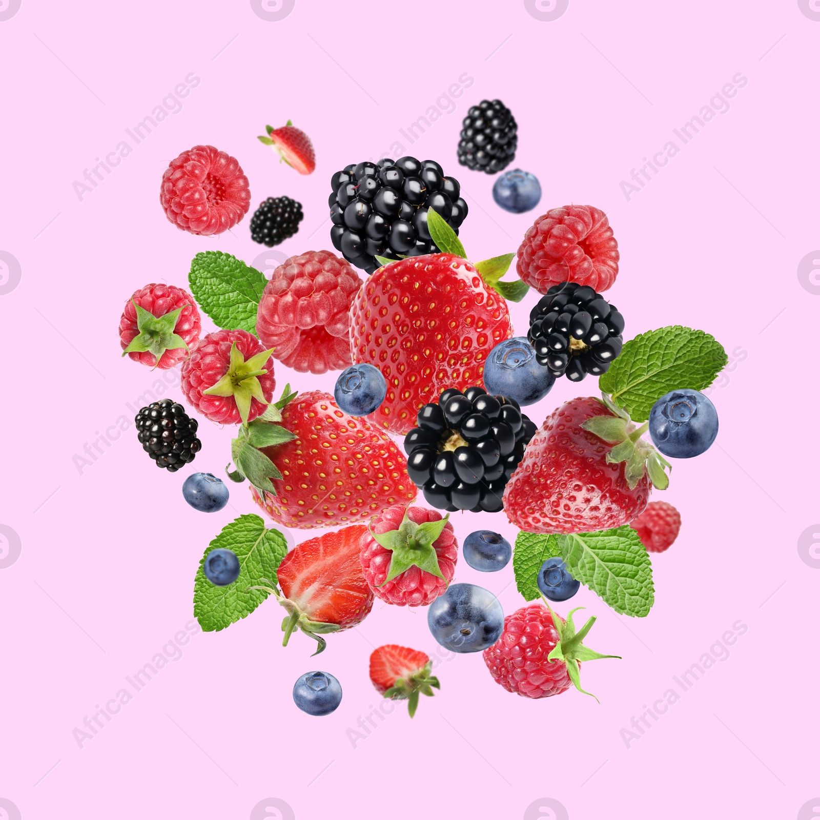 Image of Mix of fresh berries in air on pink background