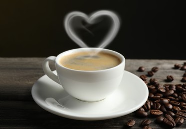 Image of Fresh aromatic coffee and beans on wooden table. Steam in shape of heart over cup