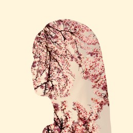 Silhouette of woman filled with blossoming spring tree on beige background. Concept of beauty, femininity and inner peace