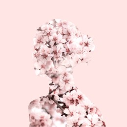 Silhouette of woman filled with blossoming spring tree on pink background. Concept of beauty, femininity and inner peace