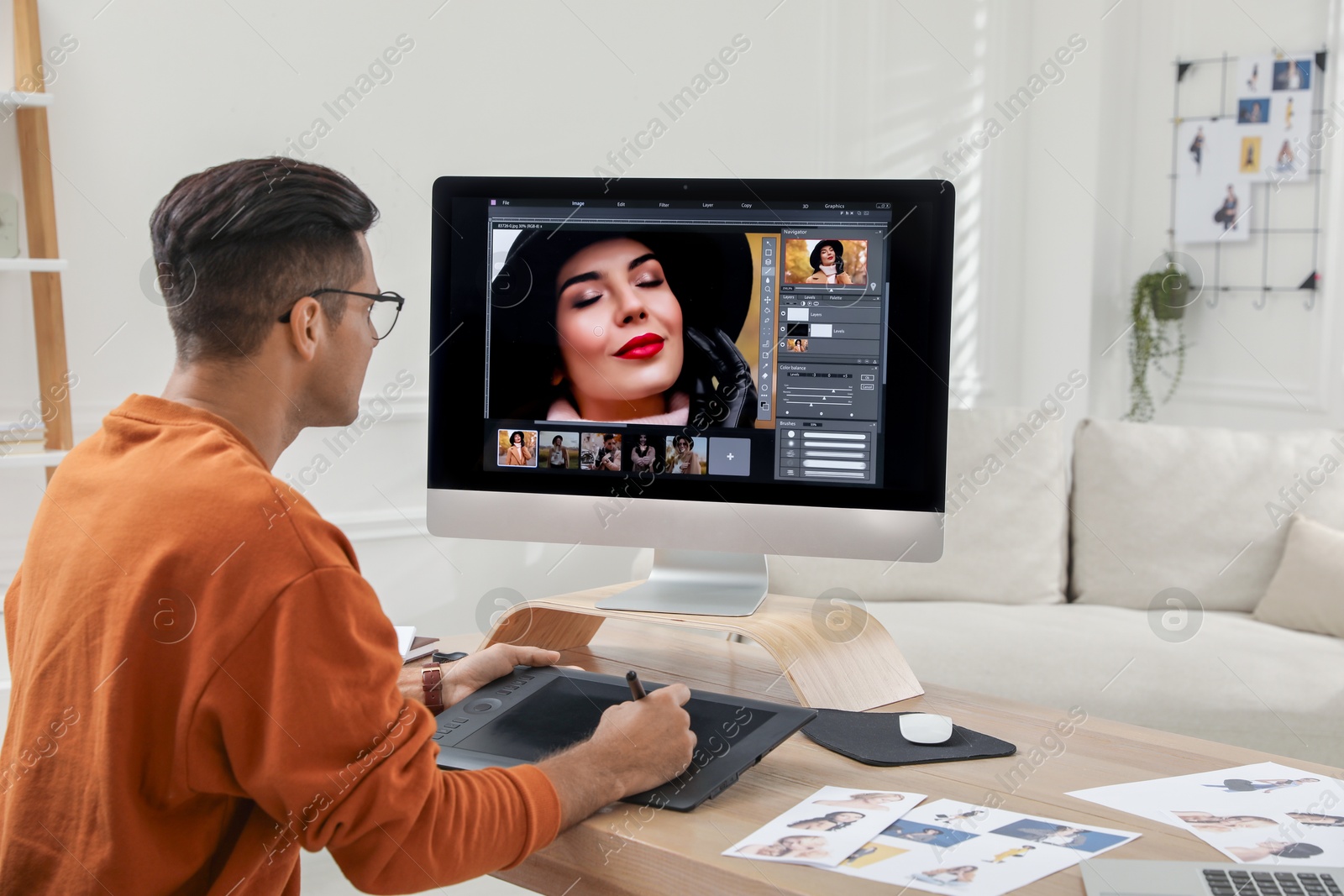 Photo of Professional retoucher working with graphic tablet at desk in office