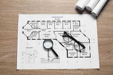 Photo of Different engineering drawings, glasses and magnifying glass on wooden table, top view