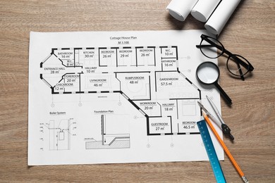 Photo of Different engineering drawings, pencil, dividers, ruler, glasses and magnifying glass on wooden table, flat lay