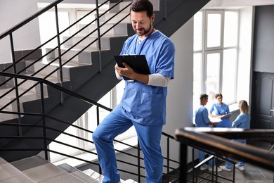 Photo of Healthcare workers in hospital, selective focus. Nurse with clipboard indoors