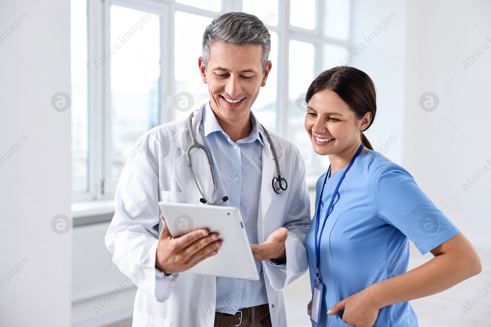 Photo of Smiling healthcare workers with tablet in hospital