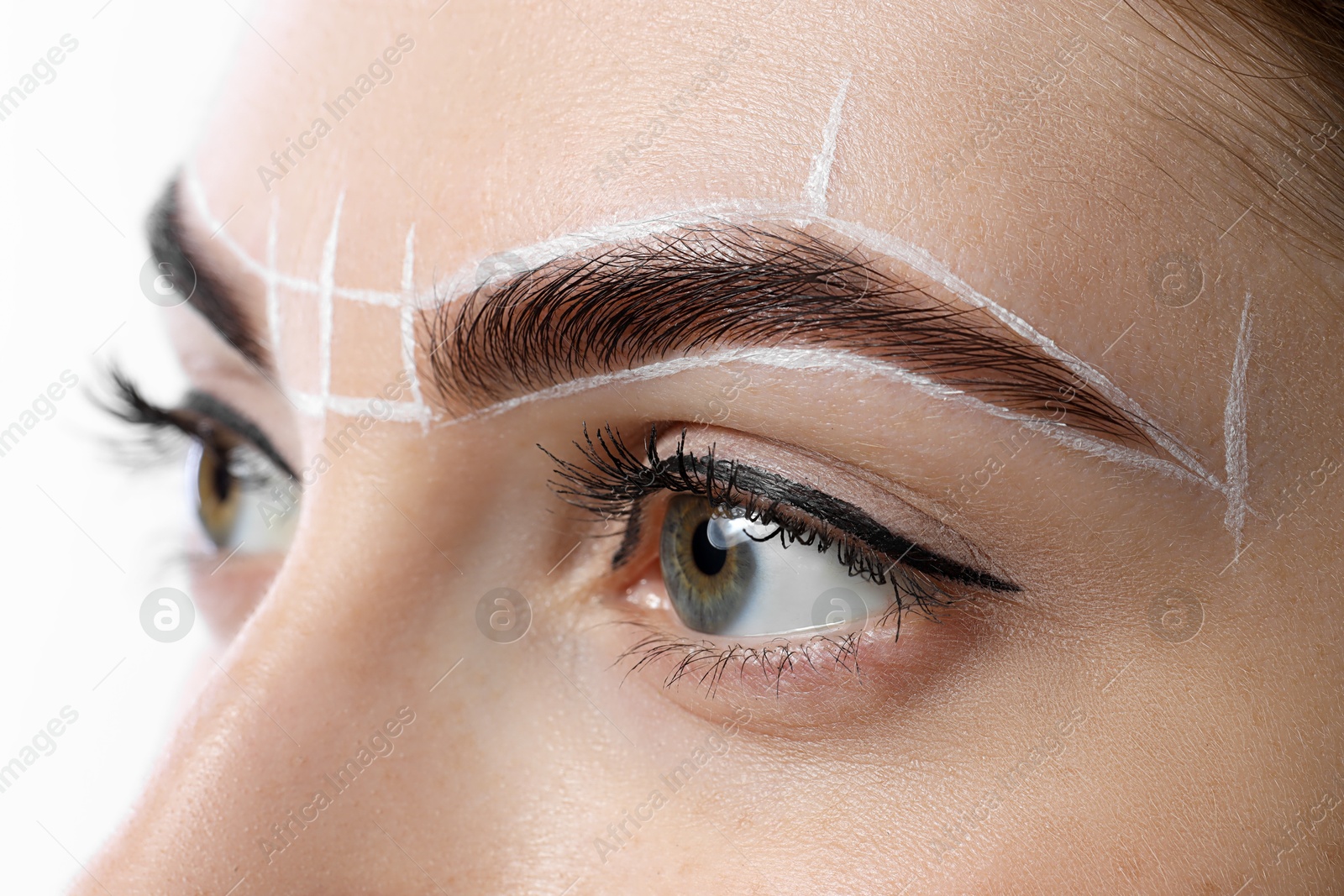 Photo of Young woman during henna eyebrows dyeing procedure on white background, closeup