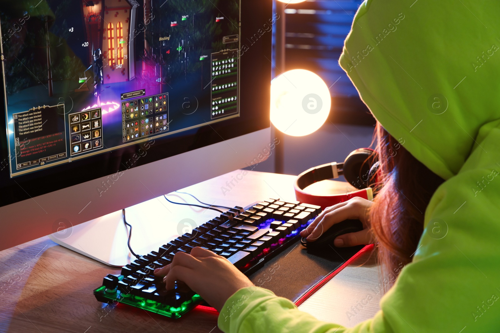 Photo of Girl playing video game with keyboard and mouse at table indoors