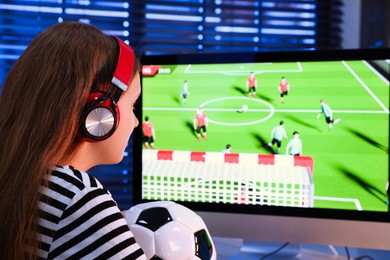 Photo of Football fan with soccer ball watching game live stream indoors