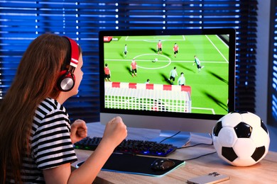 Photo of Football fan watching game live stream at table with computer keyboard, smartphone, mouse and soccer ball