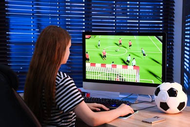 Photo of Girl playing video game with keyboard at table indoors