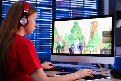 Photo of Girl playing video game with keyboard and mouse at table in dark room