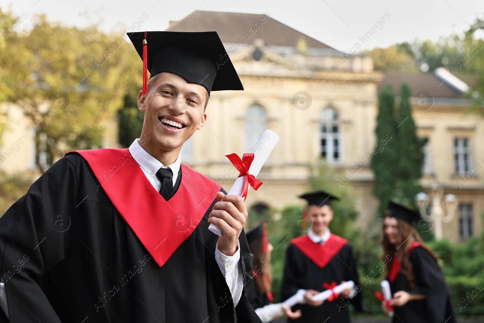 Photo of Happy students with diplomas after graduation ceremony outdoors, selective focus