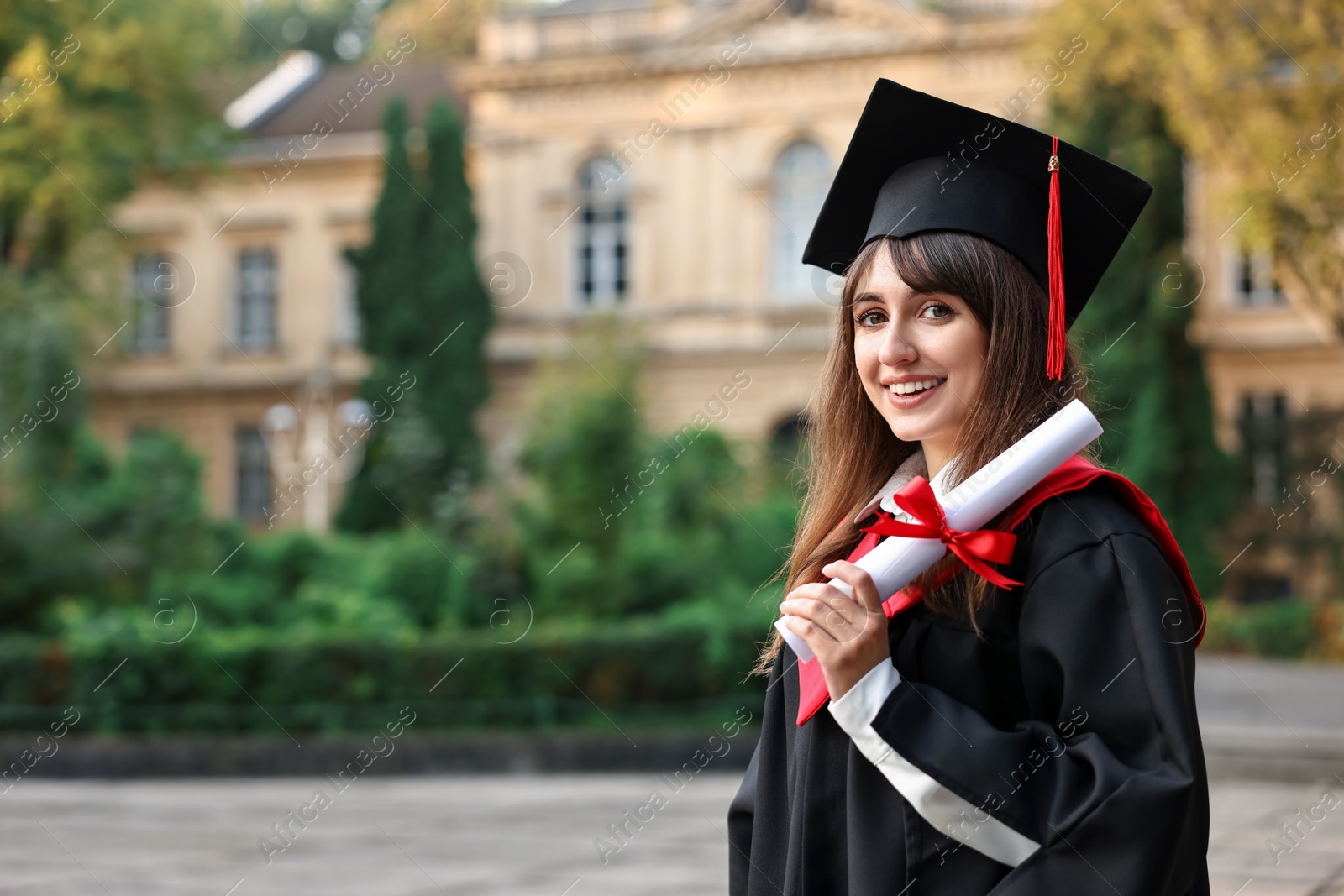 Photo of Happy student with diploma after graduation ceremony outdoors, space for text