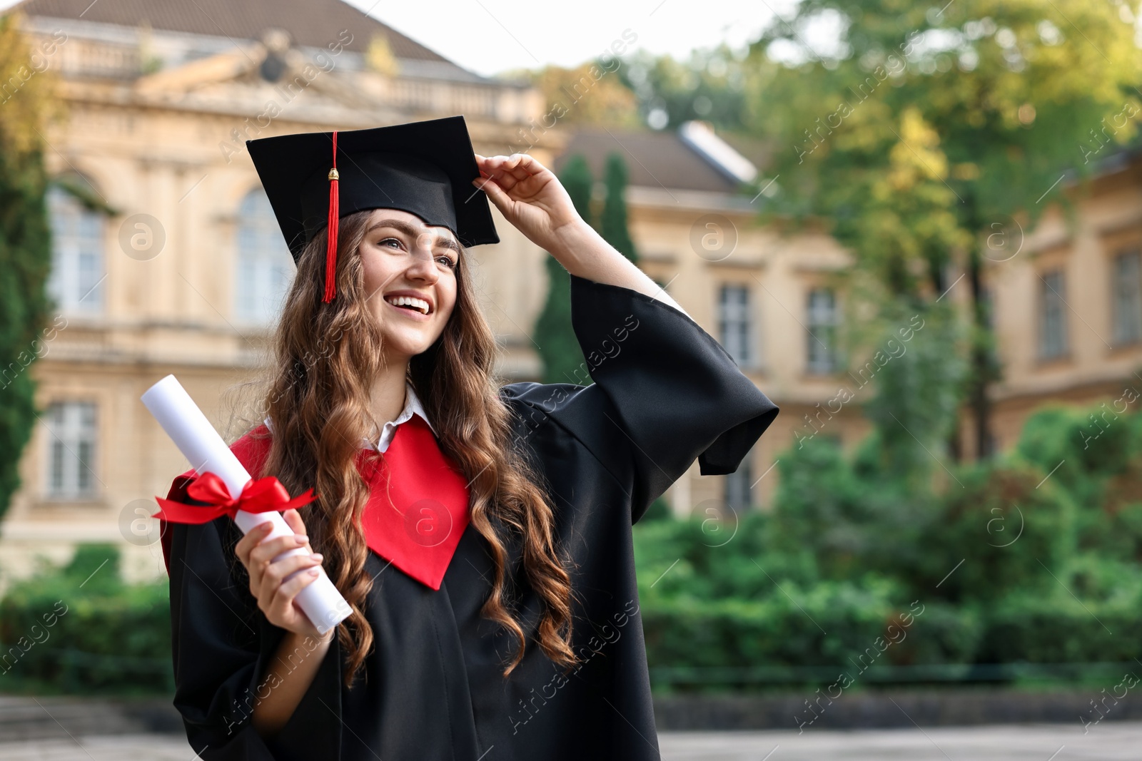 Photo of Happy student with diploma after graduation ceremony outdoors, space for text