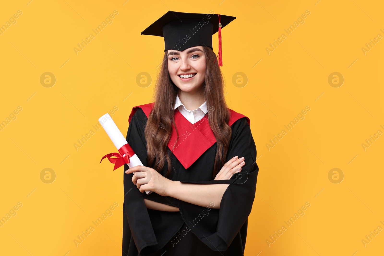 Photo of Happy student with diploma after graduation on orange background