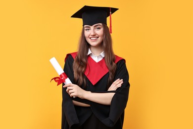 Photo of Happy student with diploma after graduation on orange background