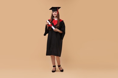 Photo of Happy student after graduation on beige background