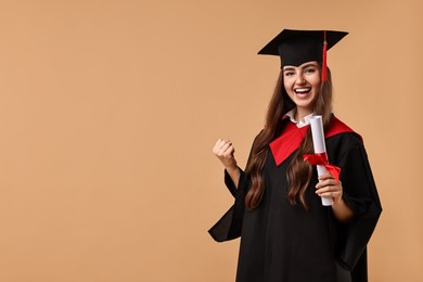 Photo of Happy student with diploma after graduation on beige background. Space for text