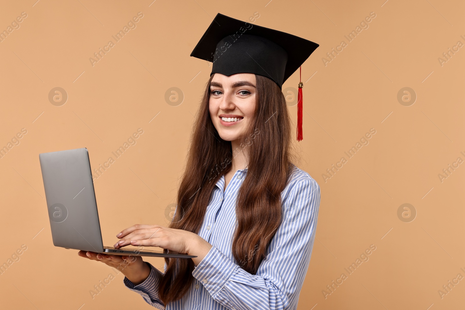 Photo of Happy student with laptop after graduation on beige background