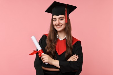 Photo of Happy student with diploma after graduation on pink background