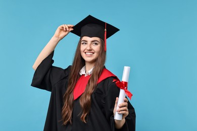 Photo of Happy student with diploma after graduation on light blue background