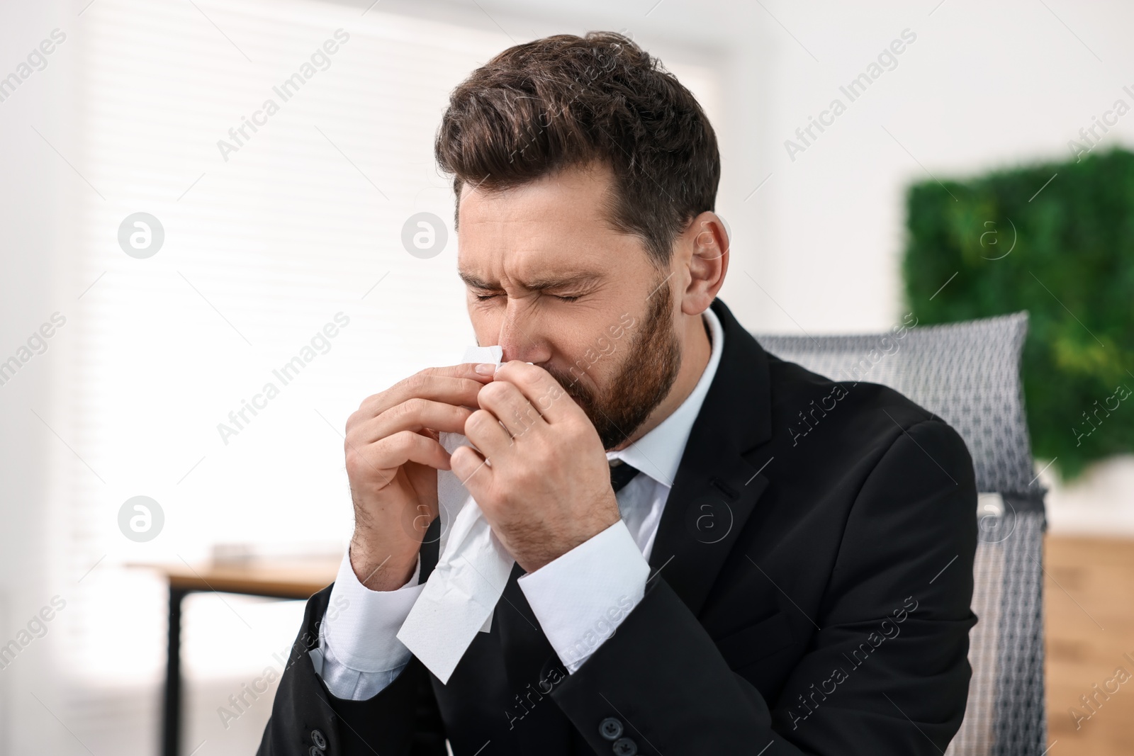 Photo of Sick man with runny nose in office