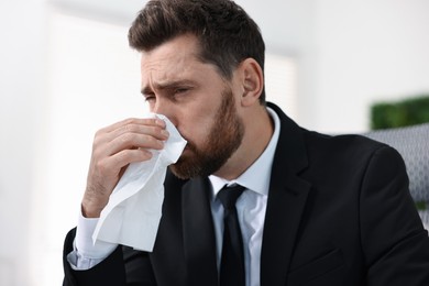 Photo of Sick man with runny nose in office