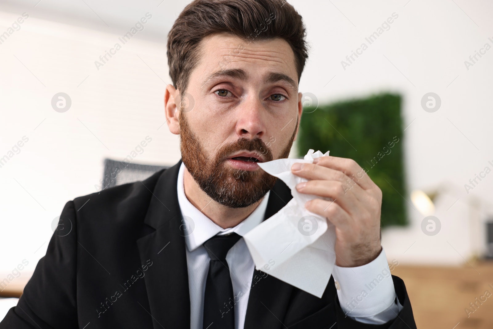 Photo of Sick man with runny nose in office