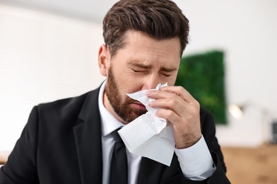 Sick man with runny nose in office