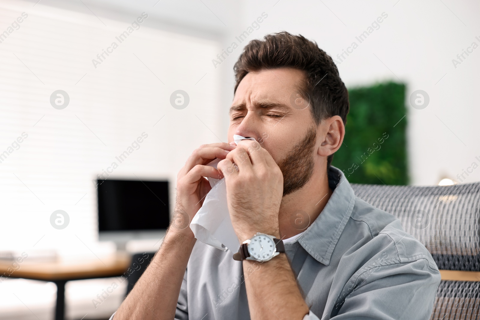 Photo of Sick man with runny nose in office