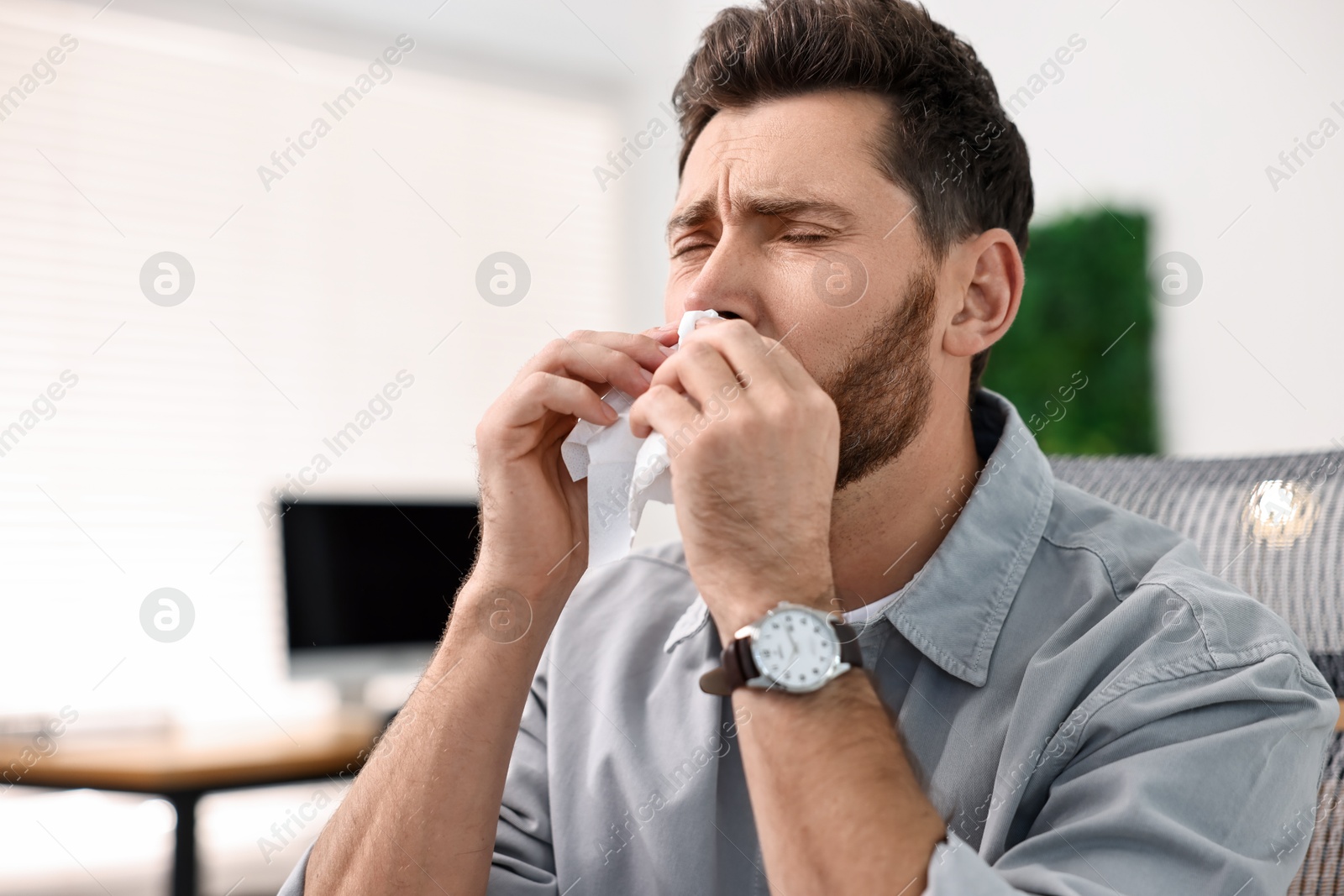 Photo of Sick man with runny nose in office